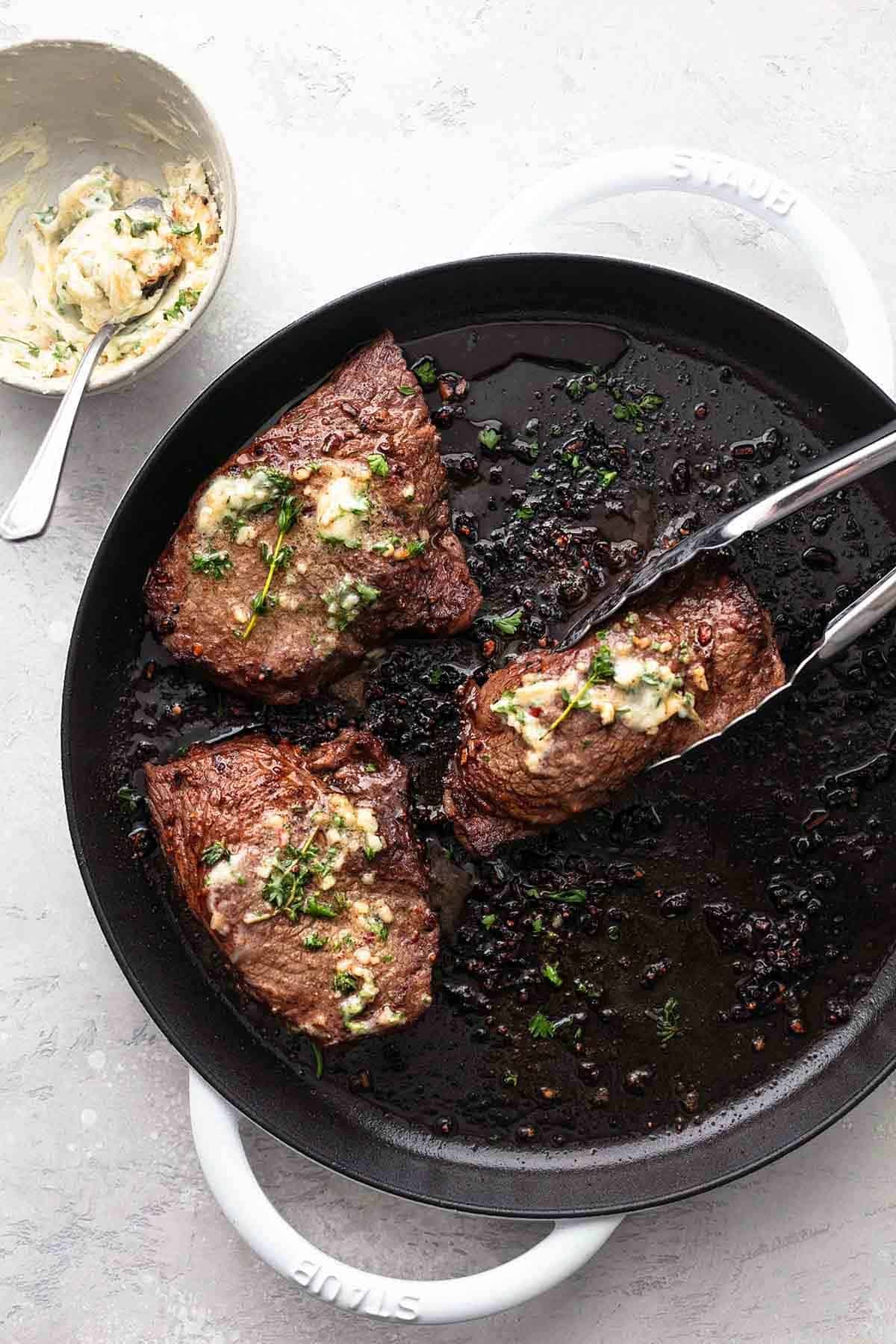Top view of sirloin steak seasoned with salt, pepper and herbs