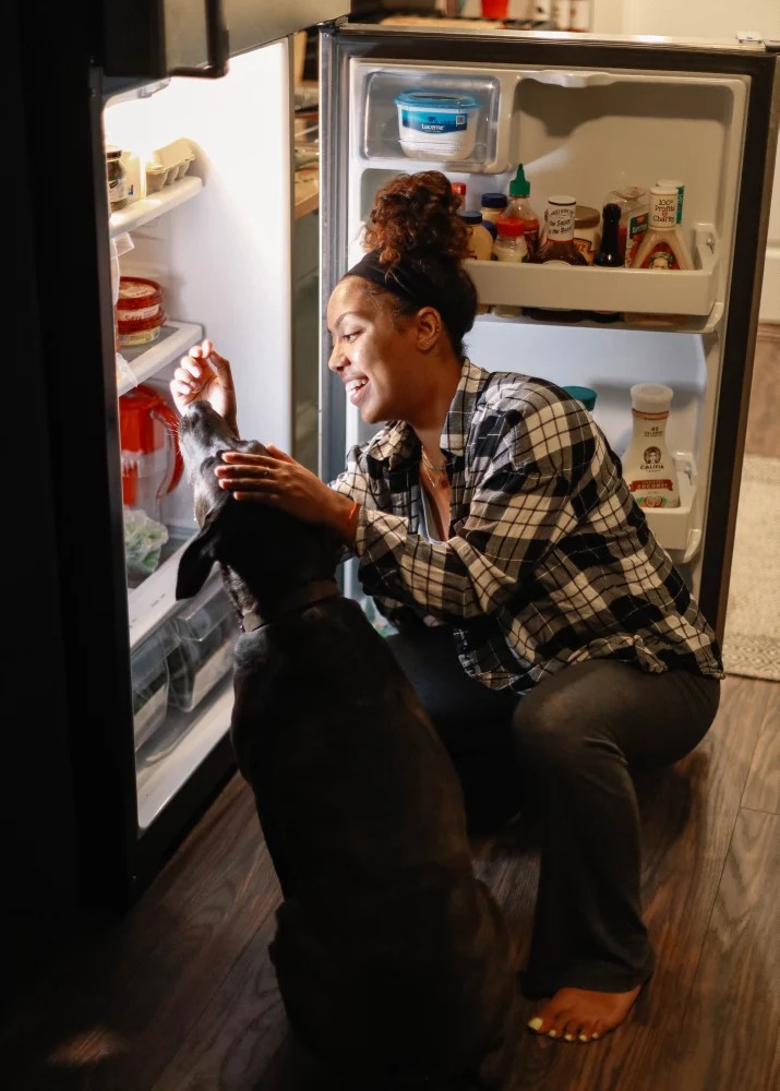 Woman and Dog near Refrigerator