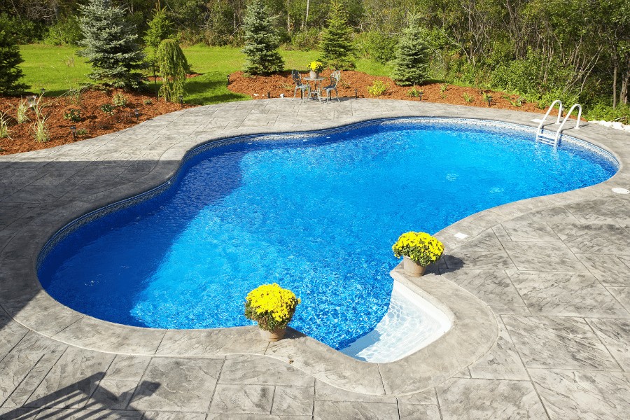 Family swimming in a backyard pool on a large property