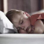 Four-year-old peacefully sleeping in bed