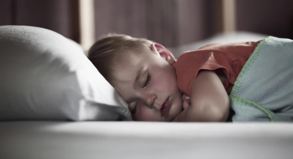 Four-year-old peacefully sleeping in bed