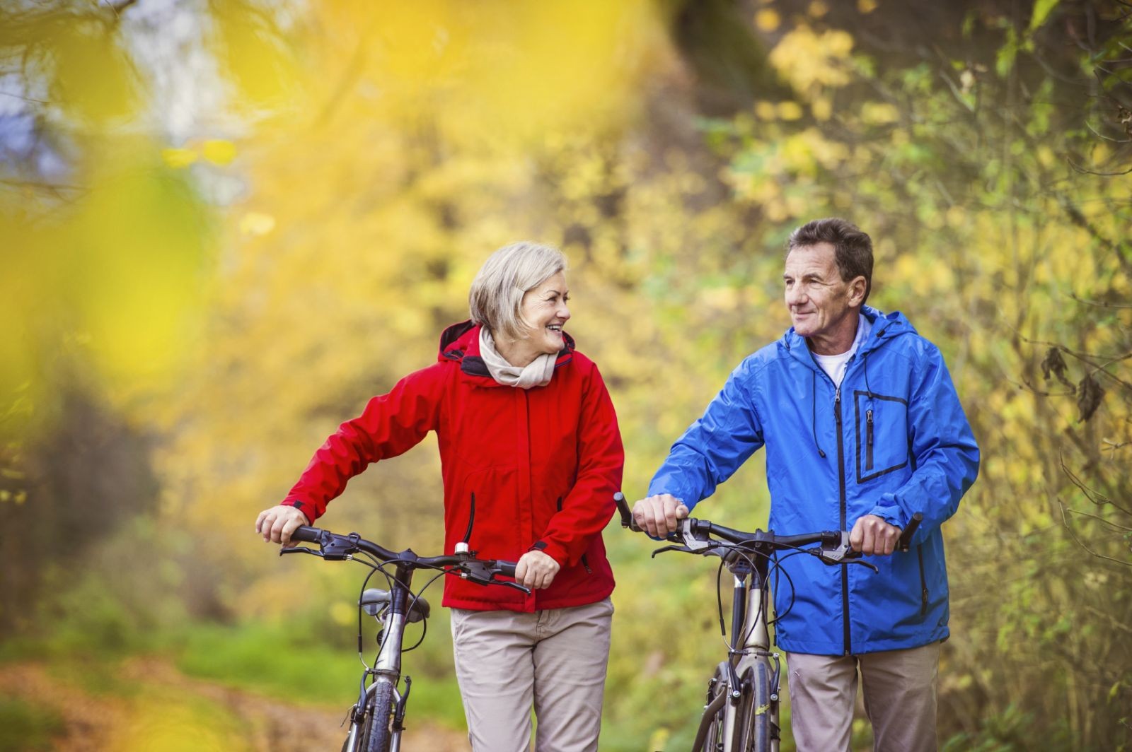 Active seniors walking with bike