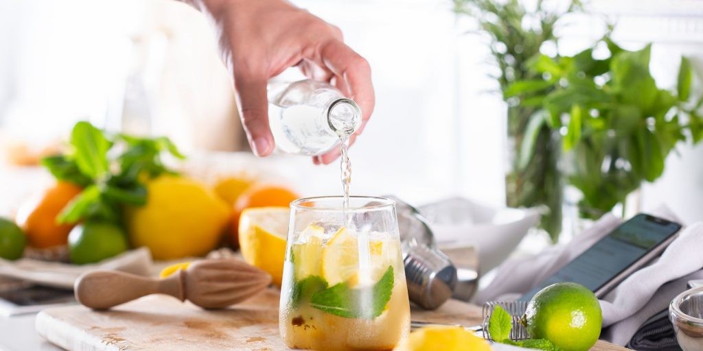 Home mixologist pouring liquid into a cocktail