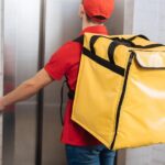 DoorDash driver carrying a delivery bag