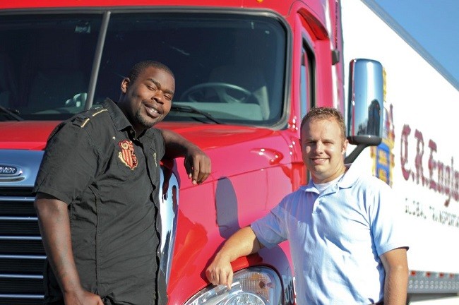 two men in front of a semi truck
