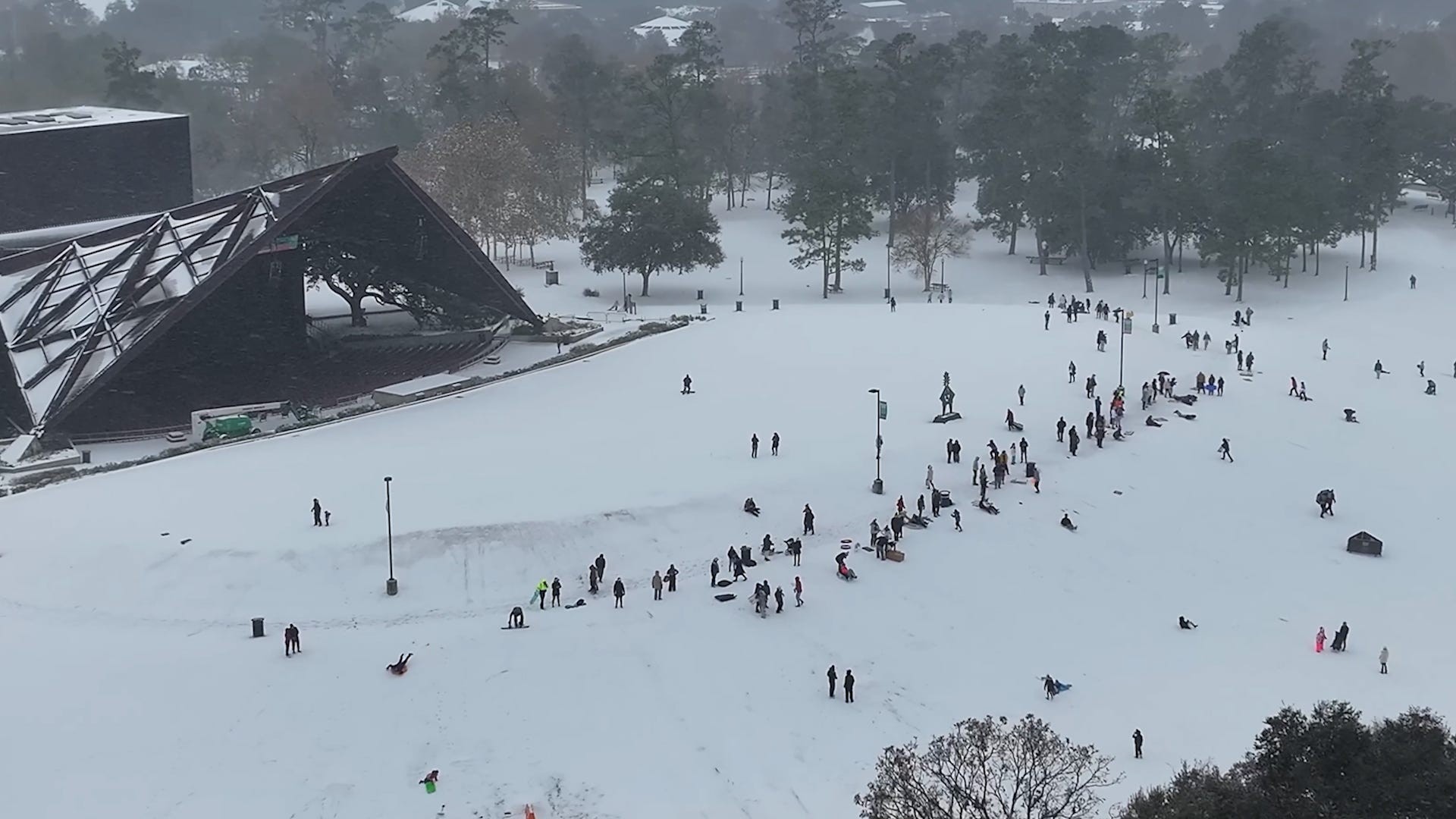Texans enjoying a rare snow day with sledding in a Houston park near the Miller Outdoor Theatre.