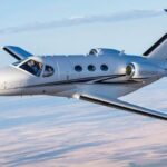 Cessna Citation Mustang flying over farmlands