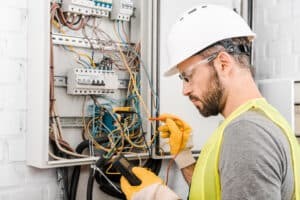 An electrician rewires an electric panel.