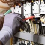 Electrician engineer tests electrical installations and wires on relay protection system. Adjustment of scheme of automation and control of electrical equipment.