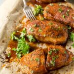 Pork chops resting on a baking sheet after baking