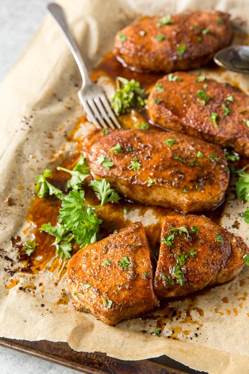 Pork chops resting on a baking sheet after baking