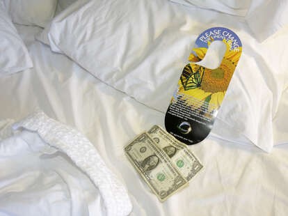 A housekeeping tip left on a hotel bed.