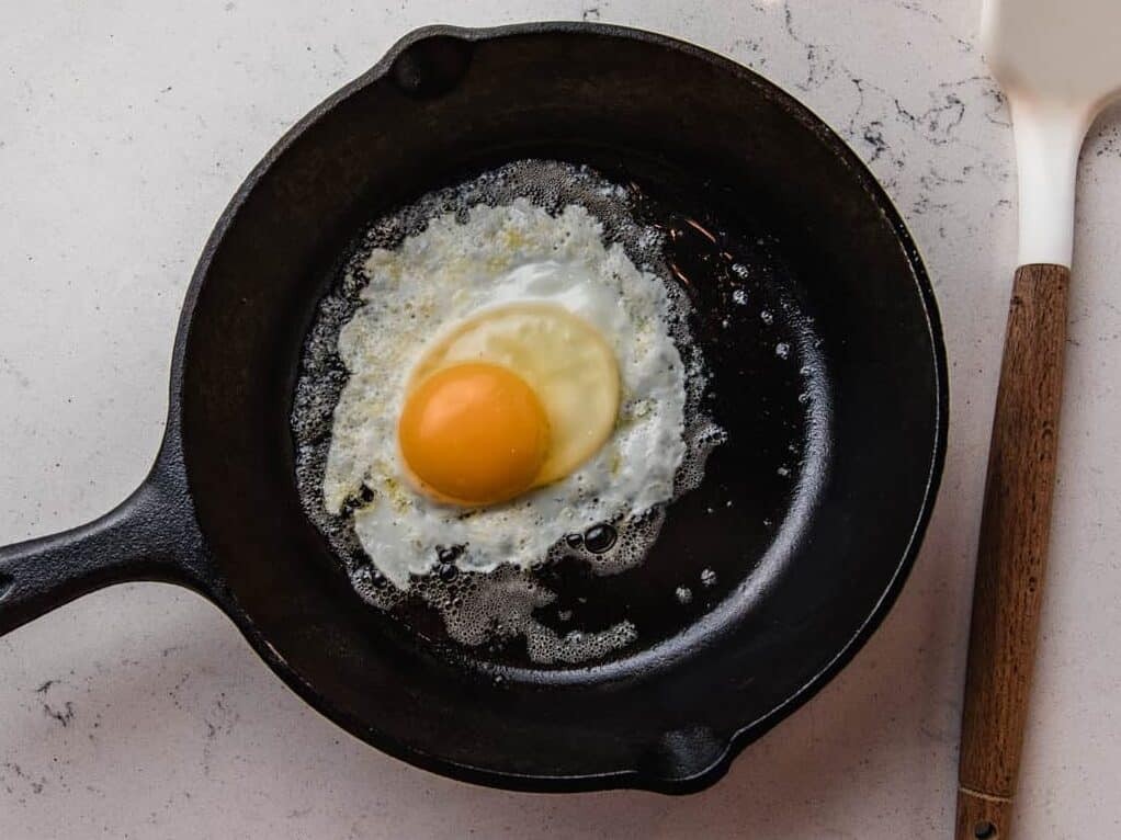 Egg frying in a cast iron pan