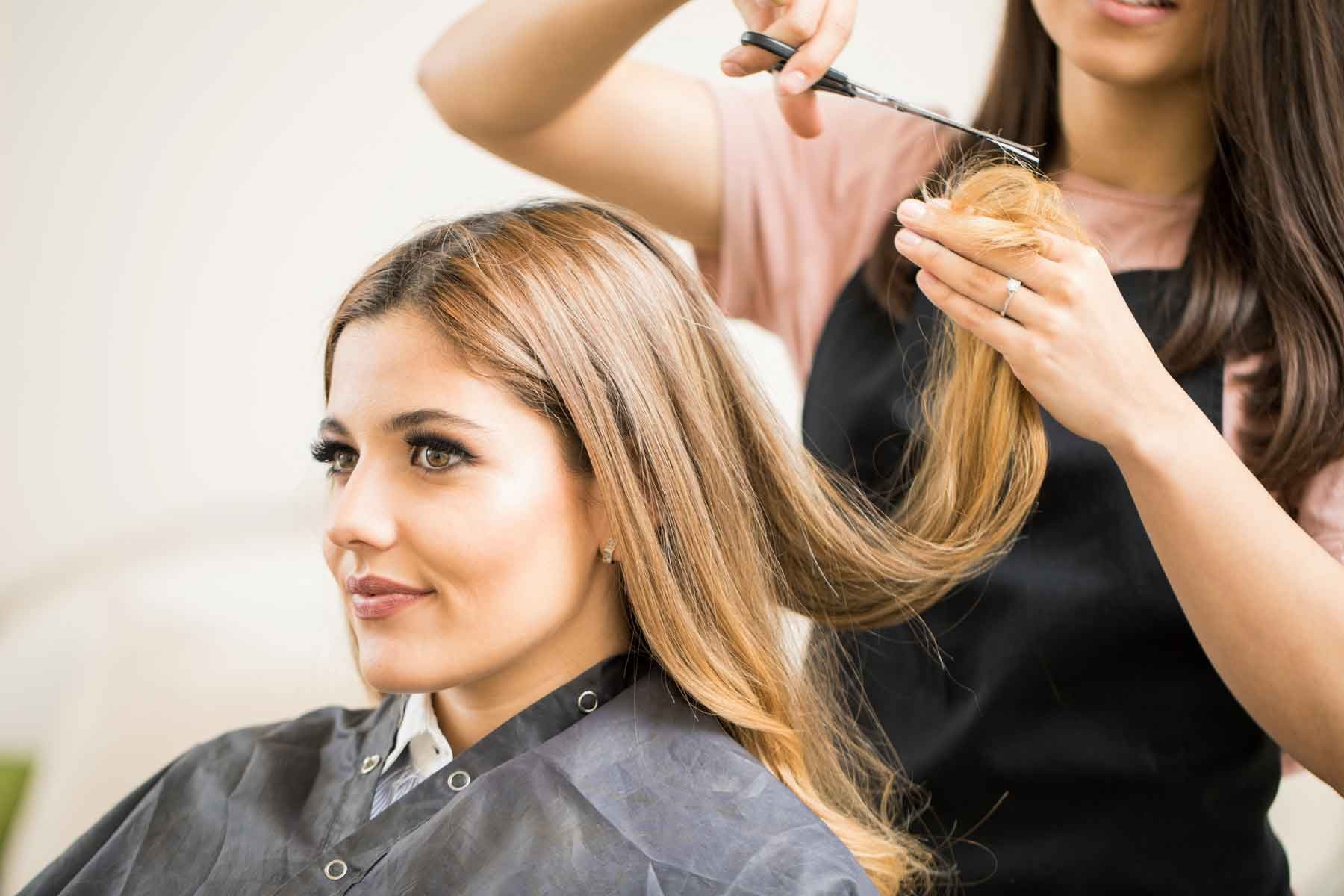 Stylist trimming a woman's hair
