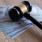 Gavel resting on a stack of $100 bills, symbolizing the financial aspects of a legal career.