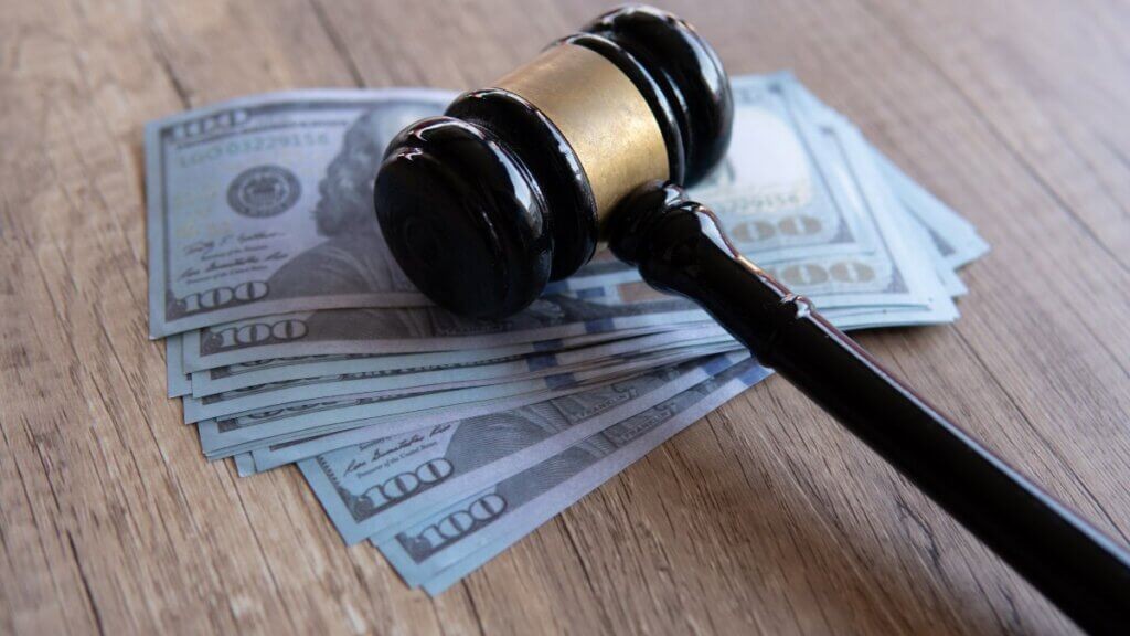 Gavel resting on a stack of $100 bills, symbolizing the financial aspects of a legal career.
