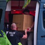 Homeland Security Investigation agents load a box into a car at the entrance of Diddy’s Miami home in March