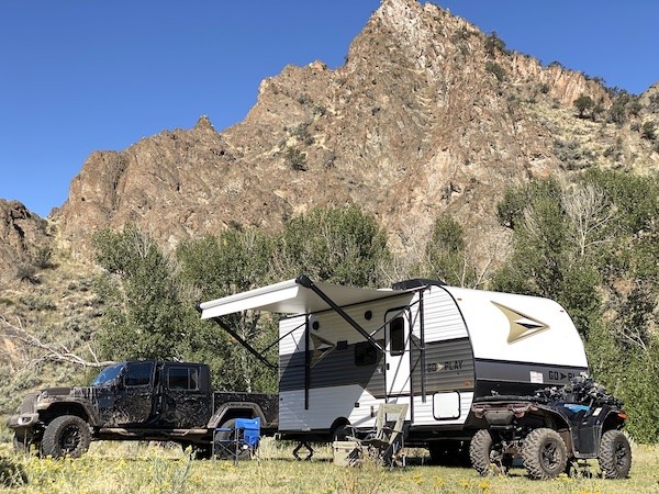 Go Play travel trailer with ATV camping in rugged terrain