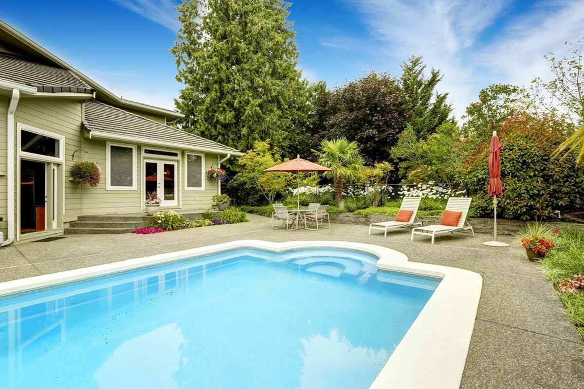 Backyard inground vinyl pool with patio and lounge area