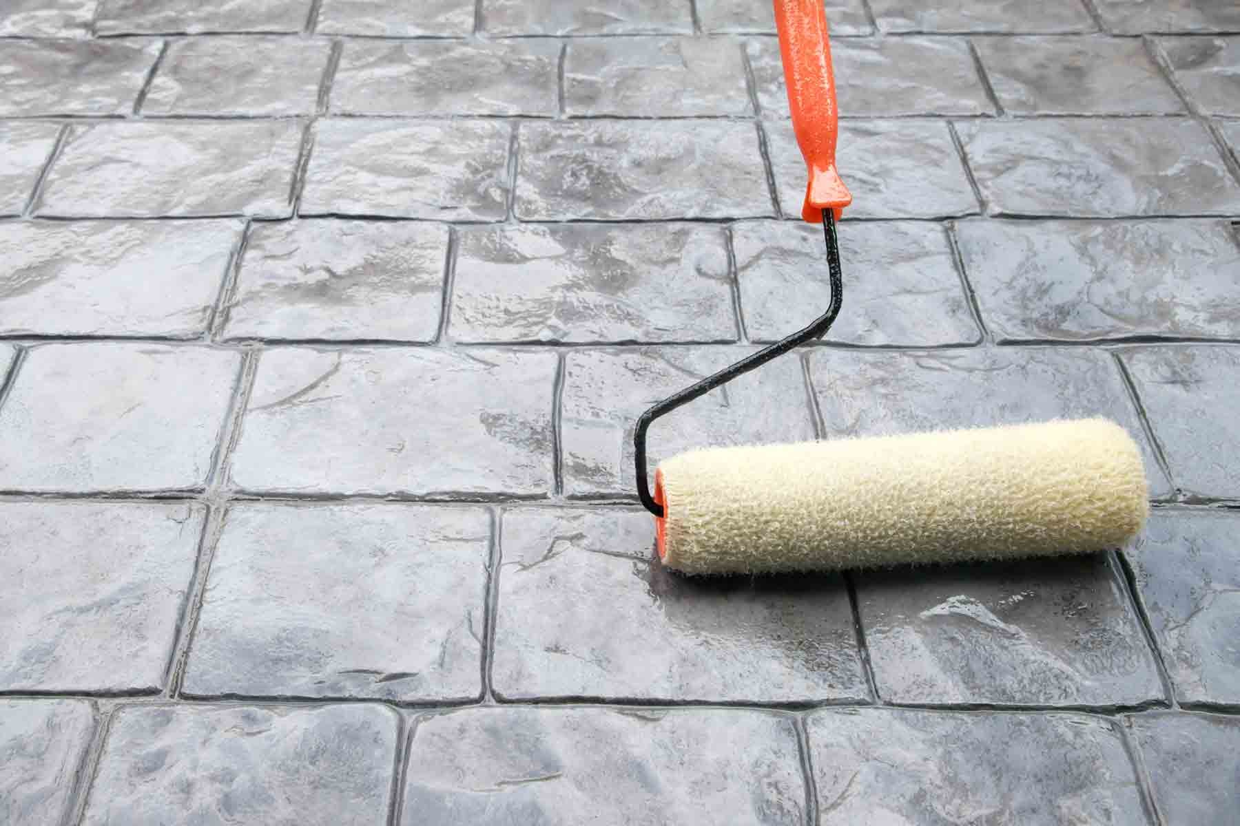 Sealing a stamped concrete patio to protect and waterproof it.