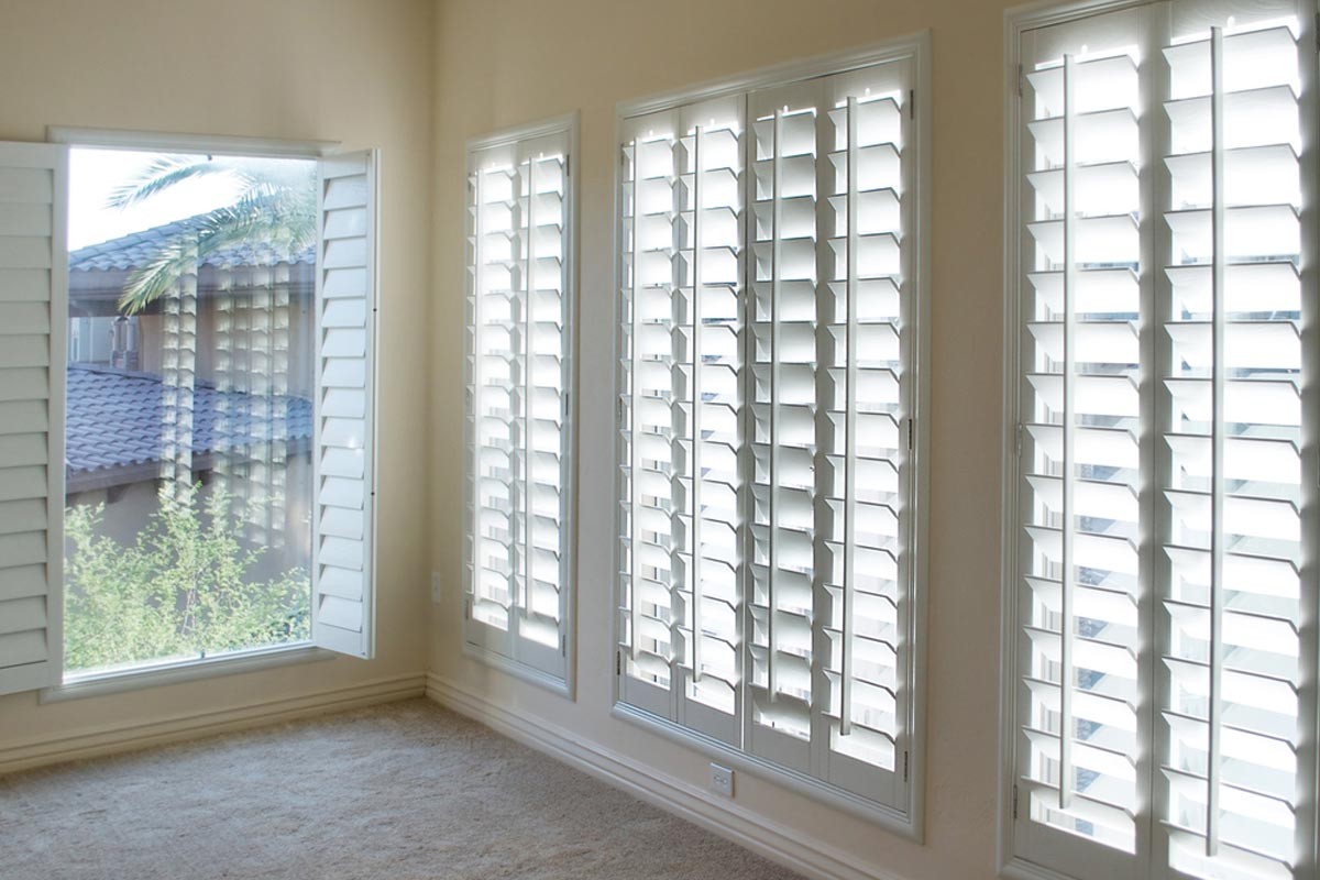 White faux composition plantation shutters in bedroom