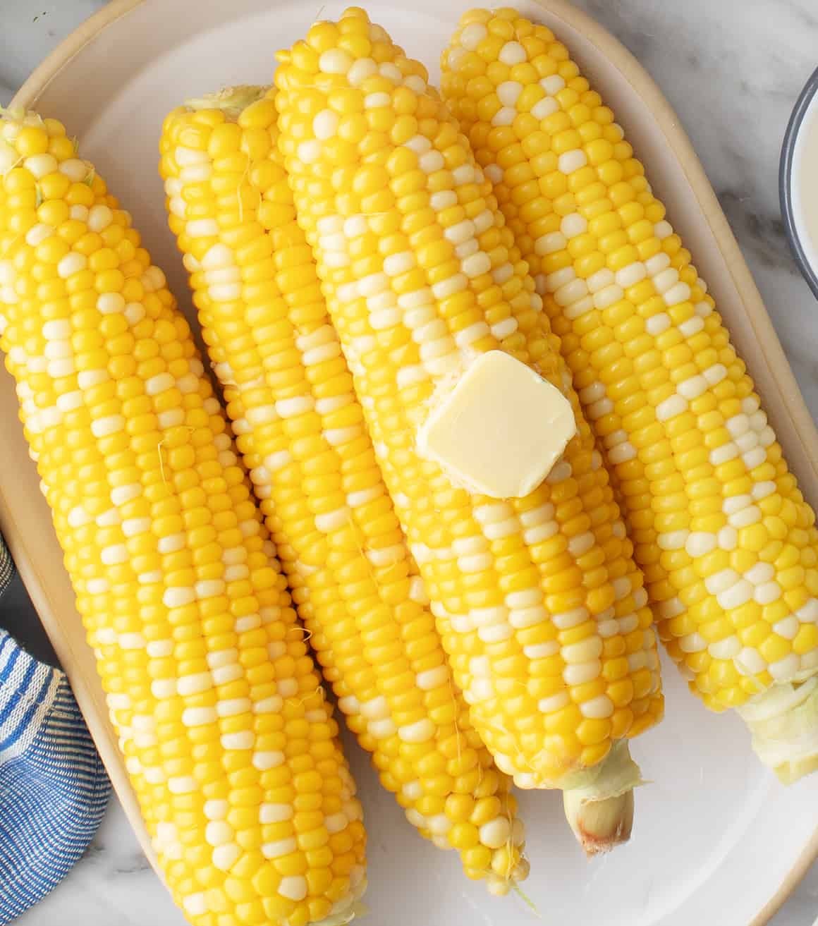 Platter of cooked corn on the cob with butter