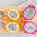 Dragon fruit sliced in half, revealing the white flesh and black seeds