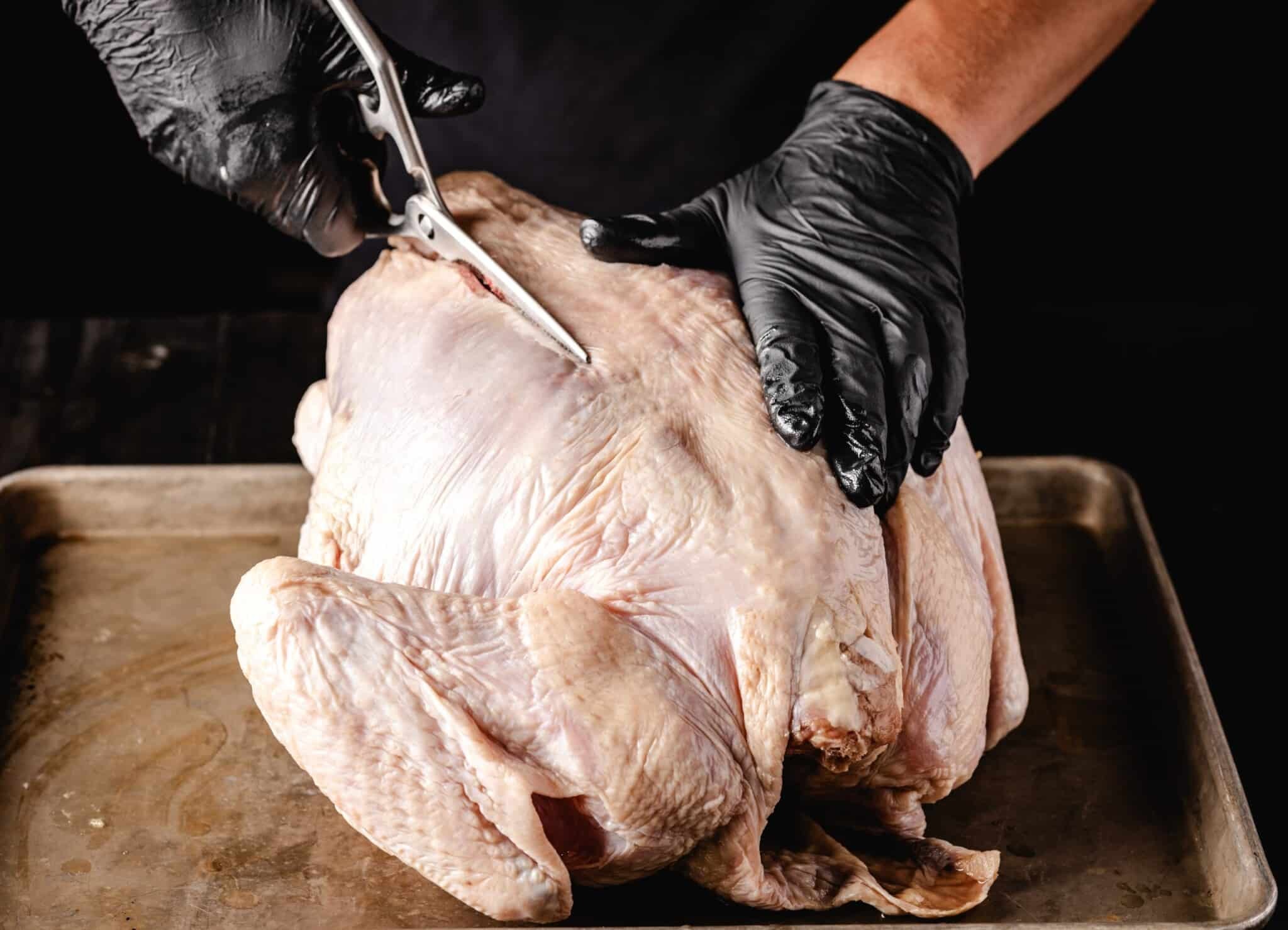 Prepared turkey on a cutting board, ready for spatchcocking.