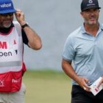 PGA Tour caddie wearing a hat