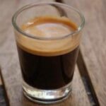 A close-up shot of a freshly brewed espresso with a rich crema