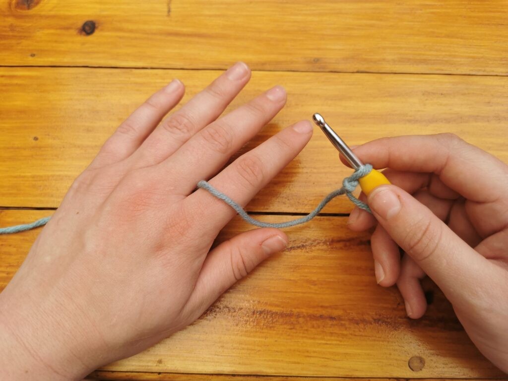 Place the yarn between your middle and index finger