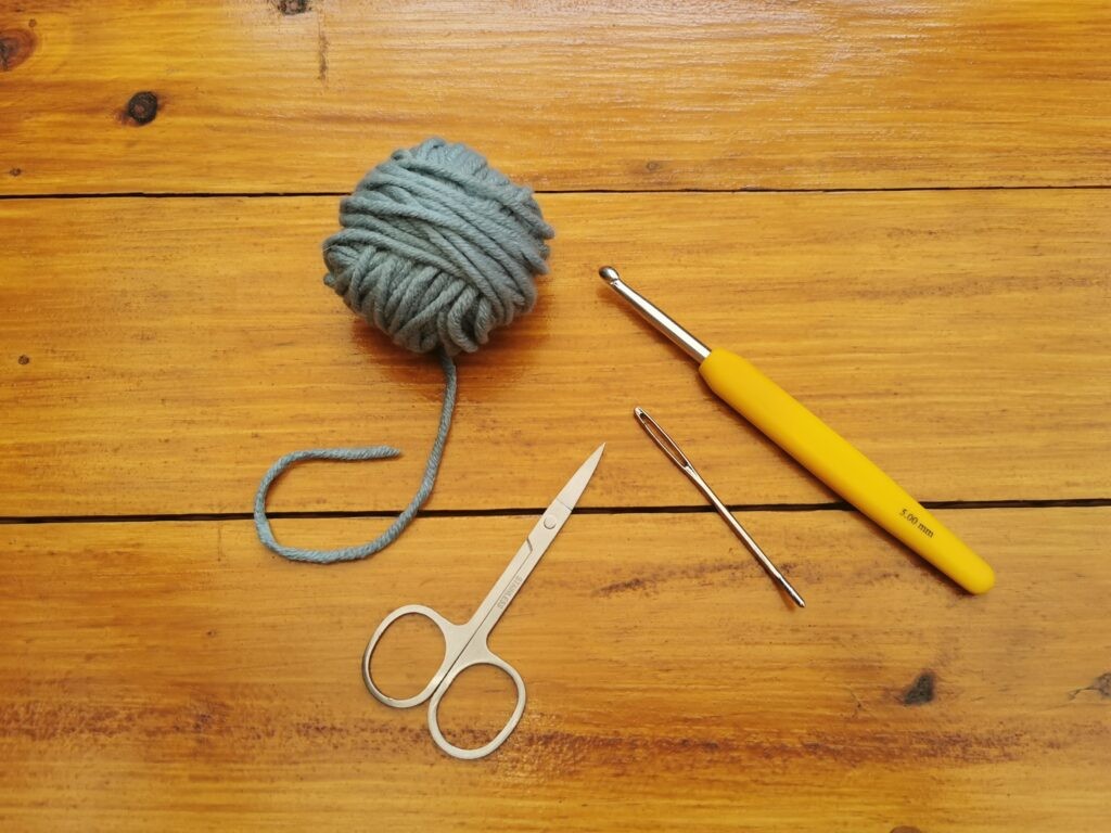 Crochet supplies, including yarn, hooks, scissors, and yarn needle