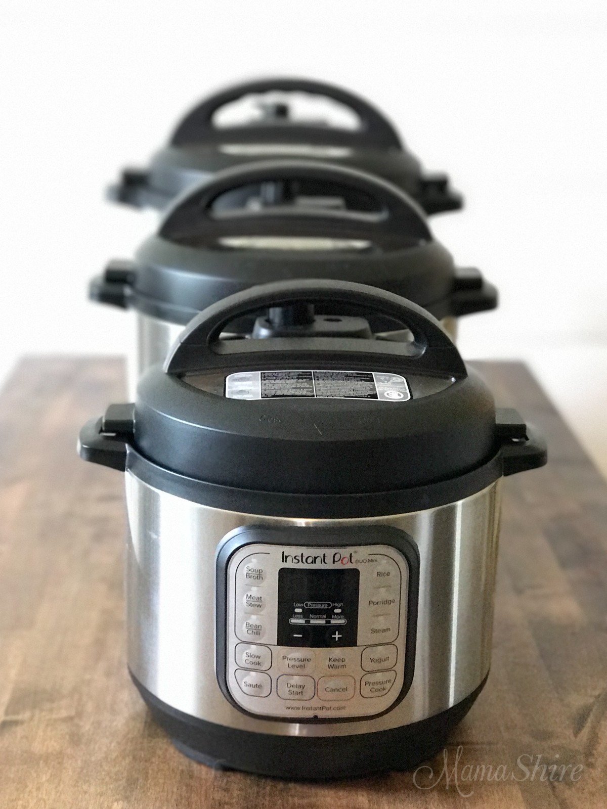 Three Instant Pots of different sizes (3 qt, 6 qt, and 8 qt) displayed on a kitchen counter, each with a steamer basket inside, illustrating the relative capacity differences.