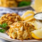 Close-up view of golden brown, Maryland-style crab cakes on a plate.