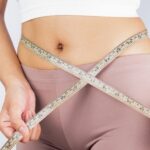 Woman using flexible measuring tape for clothing size
