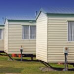 Mobile home movers inspect the condition of a single-wide home before transport, ensuring road safety and compliance with regulations mobile home movers