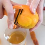 Peeling an orange for an Old Fashioned cocktail