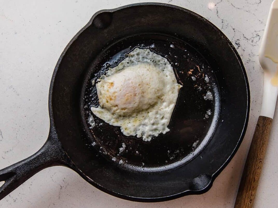 Over easy egg flipped over in a pan