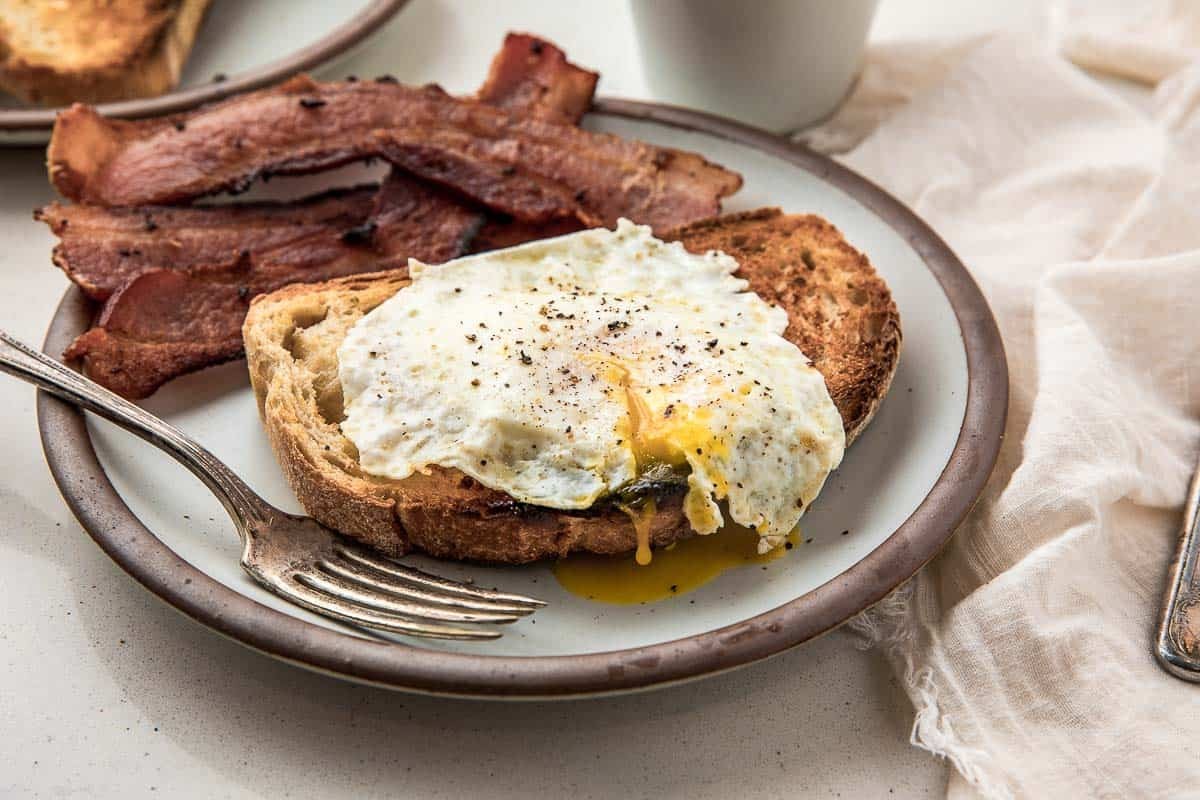 Over easy eggs with bacon and toast