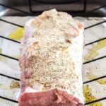 Pork loin seasoned and ready for the oven, showcasing the marbling and fat cap