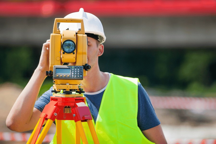 A land surveyor using equipment to measure land