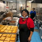 Cafeteria worker serving food to students