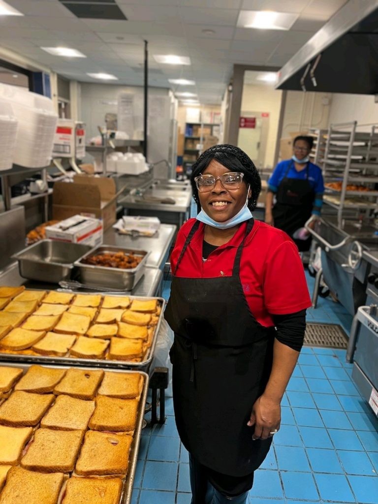 Cafeteria worker serving food to students