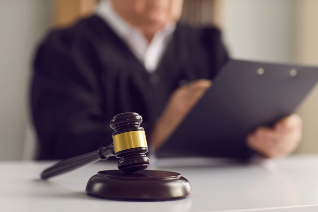 A gavel sitting on top of legal documents.