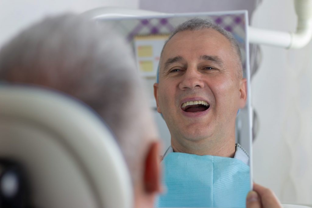 Dental professional explaining a single tooth implant process with a model.