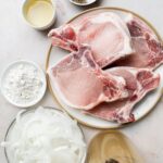 Overhead view of raw pork loin chops with seasoning