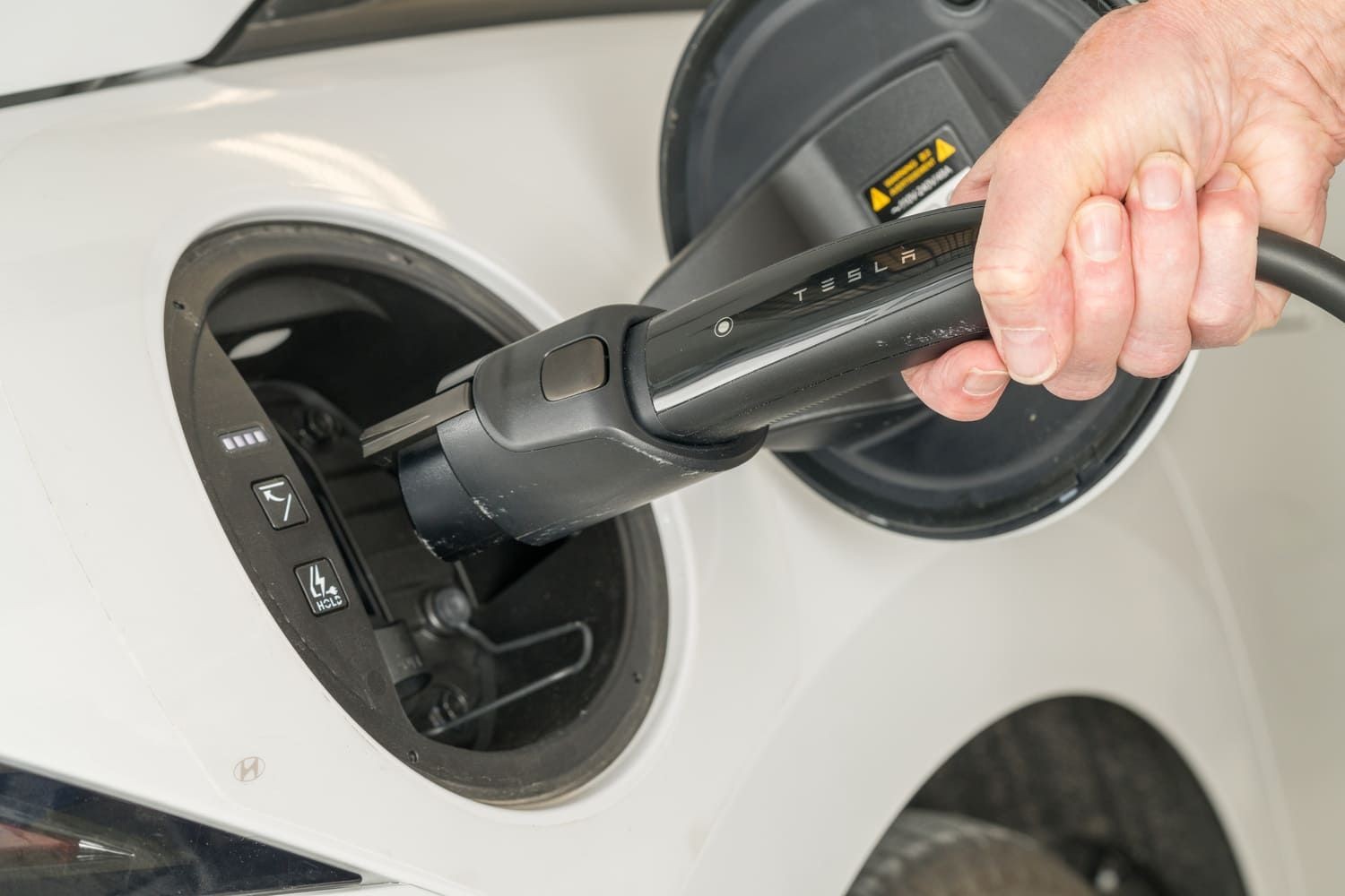 Plugging in a white Tesla