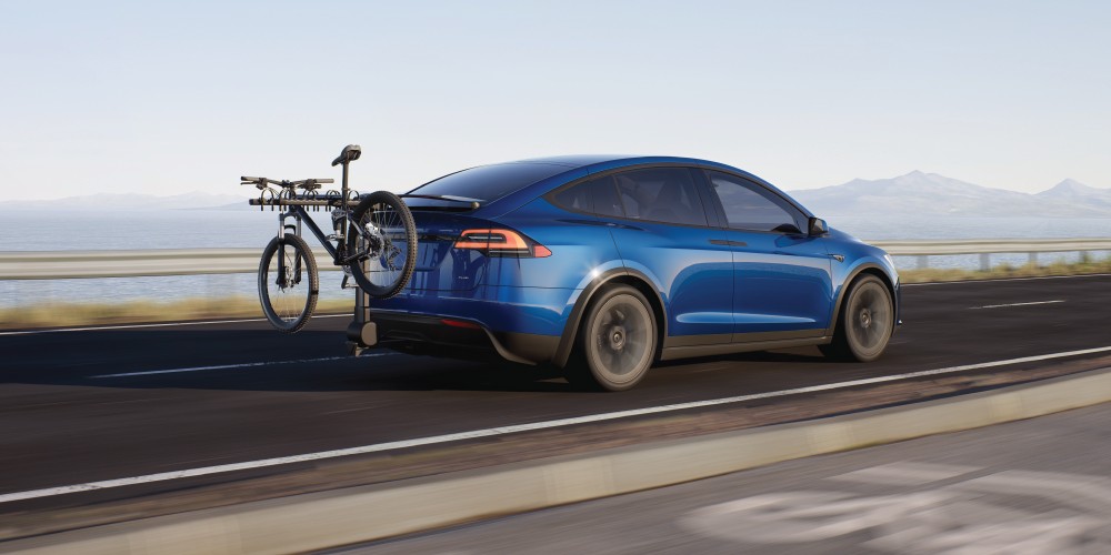 A Tesla Model X is parked in front of a house