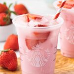 A visually appealing starbucks pink drink in a clear glass