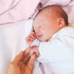 A mom holding a baby in the nursery